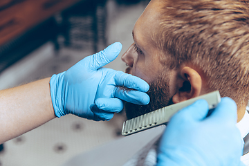 Image showing Man getting hair cut at the barbershop wearing mask during coronavirus pandemic