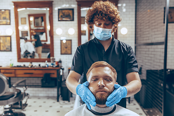 Image showing Man getting hair cut at the barbershop wearing mask during coronavirus pandemic