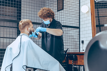 Image showing Man getting hair cut at the barbershop wearing mask during coronavirus pandemic