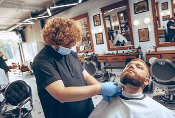 Image showing Man getting hair cut at the barbershop wearing mask during coronavirus pandemic