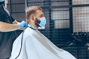 Image showing Man getting hair cut at the barbershop wearing mask during coron