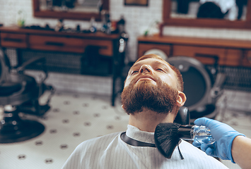 Image showing Man getting hair cut at the barbershop wearing mask during coronavirus pandemic