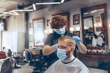 Image showing Man getting hair cut at the barbershop wearing mask during coronavirus pandemic