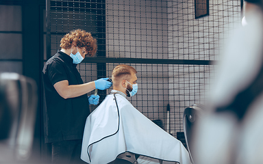 Image showing Man getting hair cut at the barbershop wearing mask during coronavirus pandemic