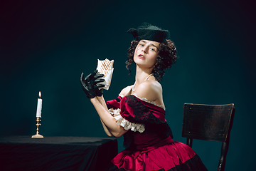 Image showing Young woman as Anna Karenina on dark blue background. Retro style, comparison of eras concept.