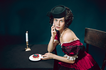 Image showing Young woman as Anna Karenina on dark blue background. Retro style, comparison of eras concept.