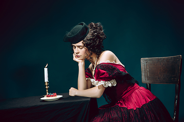 Image showing Young woman as Anna Karenina on dark blue background. Retro style, comparison of eras concept.