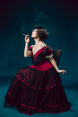 Image showing Young woman as Anna Karenina on dark blue background. Retro style, comparison of eras concept.