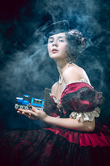 Image showing Young woman as Anna Karenina on dark blue background. Retro style, comparison of eras concept.