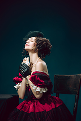 Image showing Young woman as Anna Karenina on dark blue background. Retro style, comparison of eras concept.