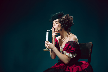 Image showing Young woman as Anna Karenina on dark blue background. Retro style, comparison of eras concept.