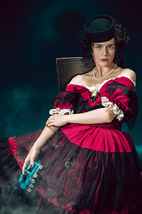 Image showing Young woman as Anna Karenina on dark blue background. Retro style, comparison of eras concept.