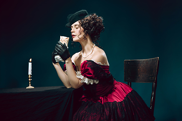 Image showing Young woman as Anna Karenina on dark blue background. Retro style, comparison of eras concept.