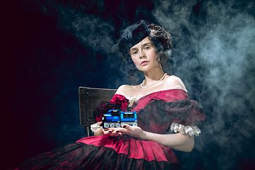 Image showing Young woman as Anna Karenina on dark blue background. Retro style, comparison of eras concept.