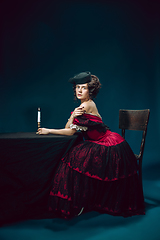 Image showing Young woman as Anna Karenina on dark blue background. Retro style, comparison of eras concept.