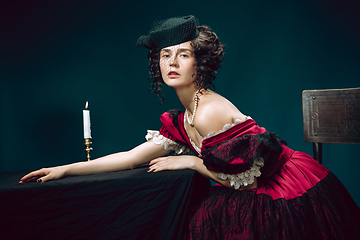 Image showing Young woman as Anna Karenina on dark blue background. Retro style, comparison of eras concept.