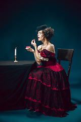 Image showing Young woman as Anna Karenina on dark blue background. Retro style, comparison of eras concept.