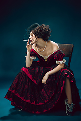 Image showing Young woman as Anna Karenina on dark blue background. Retro style, comparison of eras concept.