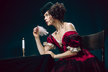 Image showing Young woman as Anna Karenina on dark blue background. Retro style, comparison of eras concept.