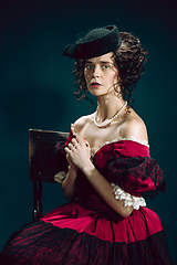 Image showing Young woman as Anna Karenina on dark blue background. Retro style, comparison of eras concept.