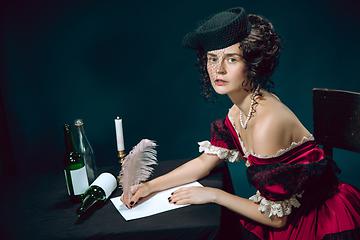 Image showing Young woman as Anna Karenina on dark blue background. Retro style, comparison of eras concept.