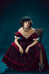 Image showing Young woman as Anna Karenina on dark blue background. Retro style, comparison of eras concept.