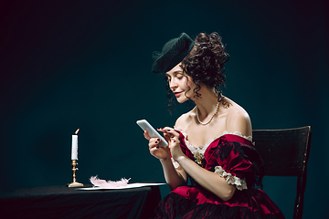 Image showing Young woman as Anna Karenina on dark blue background. Retro style, comparison of eras concept.