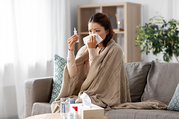 Image showing sick asian woman with nasal spray medicine at home