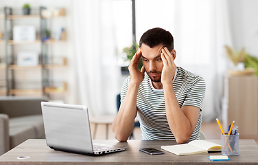 Image showing stressed man with laptop working at home office