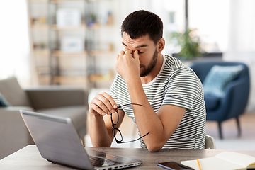 Image showing tired man with laptop working at home office