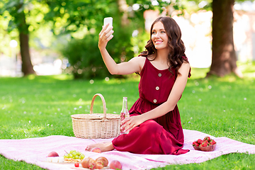 Image showing happy woman with smartphone taking selfie at park