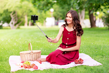 Image showing happy woman with smartphone taking selfie at park