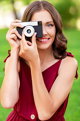 Image showing happy woman with camera photographing at park