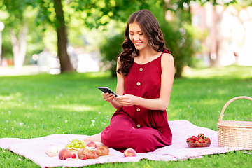 Image showing happy woman with smartphone on picnic at park