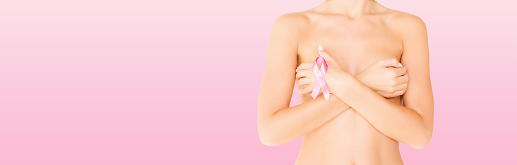 Image showing young woman checking breast for signs of cancer