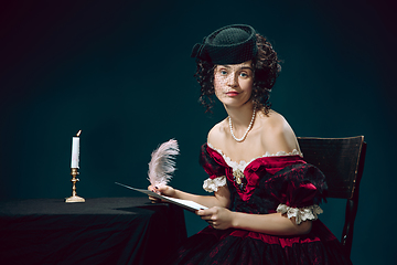 Image showing Young woman as Anna Karenina on dark blue background. Retro style, comparison of eras concept.