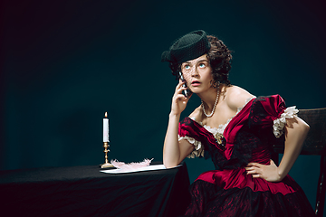 Image showing Young woman as Anna Karenina on dark blue background. Retro style, comparison of eras concept.