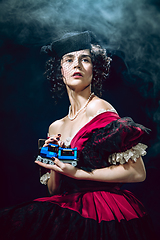 Image showing Young woman as Anna Karenina on dark blue background. Retro style, comparison of eras concept.