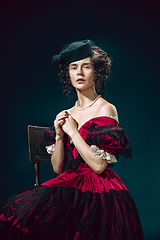 Image showing Young woman as Anna Karenina on dark blue background. Retro style, comparison of eras concept.