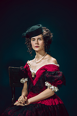 Image showing Young woman as Anna Karenina on dark blue background. Retro style, comparison of eras concept.