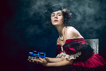 Image showing Young woman as Anna Karenina on dark blue background. Retro style, comparison of eras concept.