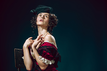 Image showing Young woman as Anna Karenina on dark blue background. Retro style, comparison of eras concept.