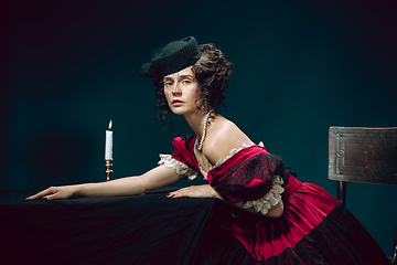 Image showing Young woman as Anna Karenina on dark blue background. Retro style, comparison of eras concept.