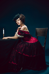 Image showing Young woman as Anna Karenina on dark blue background. Retro style, comparison of eras concept.