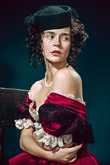 Image showing Young woman as Anna Karenina on dark blue background. Retro style, comparison of eras concept.