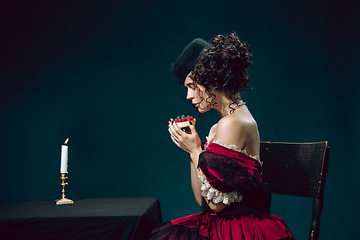 Image showing Young woman as Anna Karenina on dark blue background. Retro style, comparison of eras concept.