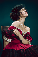 Image showing Young woman as Anna Karenina on dark blue background. Retro style, comparison of eras concept.