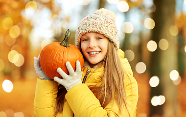 Image showing happy girl with pumpkin at autumn park