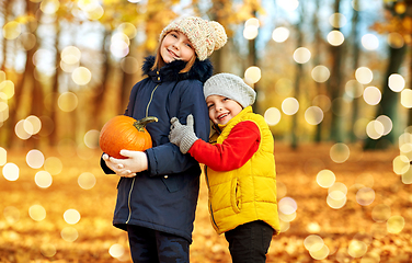 Image showing happy children with pumpkin hugging at autumn park