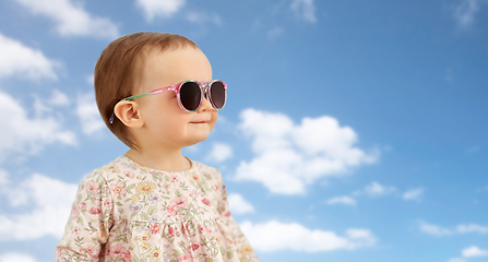 Image showing happy little baby girl in sunglasses over blue sky
